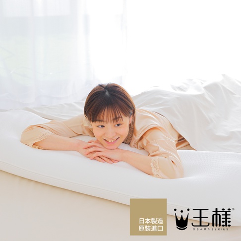 一位女子側臥在白色的長型枕頭上，枕頭表面有細緻的網格紋理。女子身穿淺棕色睡衣，露出臉部及雙臂，頭髮為深棕色短髮。背景為明亮的白色窗簾。