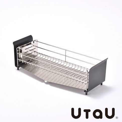 不鏽鋼窄型碗碟瀝水架，附有傾斜式瀝水盤，可收納多個碗盤。一側為黑色擋板，另一側為不鏽鋼腳座。