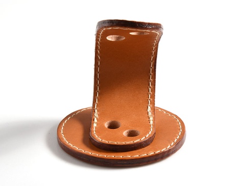 職人手作皮革兩入用筆架 (KZ-109)，淺棕色牛皮材質，以白色縫線手工縫製，底部為圓形底座，上方有兩條皮革立柱，每條立柱有兩個孔洞。