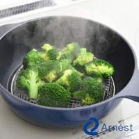 藍色鍋子裡，有銀色金屬濾網，上面擺滿了鮮綠色的花椰菜，正冒著蒸氣。