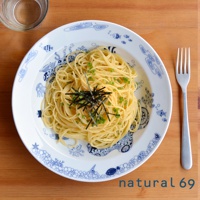 一個裝有義大利麵的白色陶瓷盤，盤邊飾有藍色海洋生物圖案，義大利麵上撒有蔥花和海苔絲。