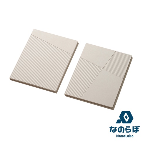 一組兩片淺米色珪藻土置物墊，表面有垂直細長紋路和斜面拼接設計，其中一片為單純紋路，另一片則由不同角度的紋路和平面拼接而成。