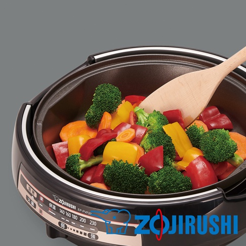 黑色鴛鴦鐵板萬用鍋 EP-PVF20 內盛滿切塊的紅、黃甜椒、花椰菜和胡蘿蔔，木製鍋鏟置於鍋中。鍋身側面有溫度顯示刻度及 Zojirushi 商標。
