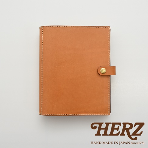 職人手作皮革A5手帳/記事本書套，淺棕色皮革，縫線整齊，設有金屬釦帶，簡約設計。
