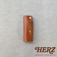 職人手作皮革鑰匙套，採用棕色皮革製成，設有金屬釦環及按鈕封口，整體呈現簡約復古風格。