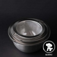 銀色不鏽鋼濾水網置於帶有刻度的大型不鏽鋼料理盆上，兩者皆為金屬材質，呈現簡潔的設計。