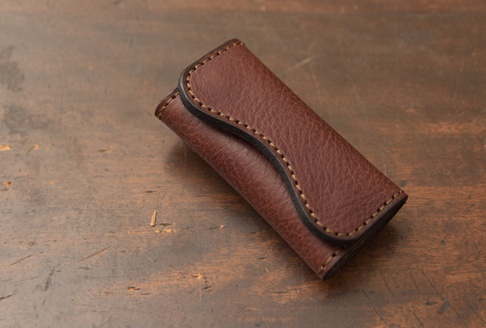 職人手作皮革鑰匙包，深棕色，復古紋理，手工縫線，附有黑色皮邊，可容納多把鑰匙。