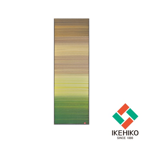 藺草編織瑜珈墊，採用漸層綠色調，從頂部的黃褐色漸變至底部的深綠色。織紋細緻，邊緣有黑色滾邊，底部右側印有品牌標誌。