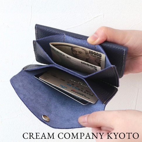 深藍色皮革手作零錢包，內有日圓鈔票及信用卡。