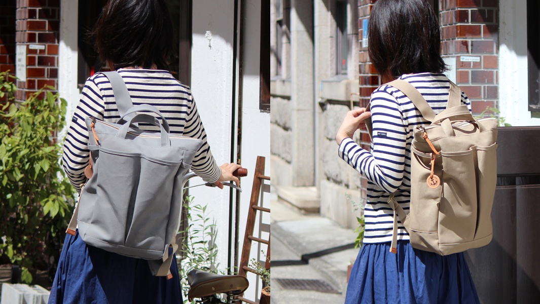 高島帆布後背包，左圖為灰色，右圖為卡其色，皆為帆布材質，兩側有置物袋，頂部有提把和肩帶。