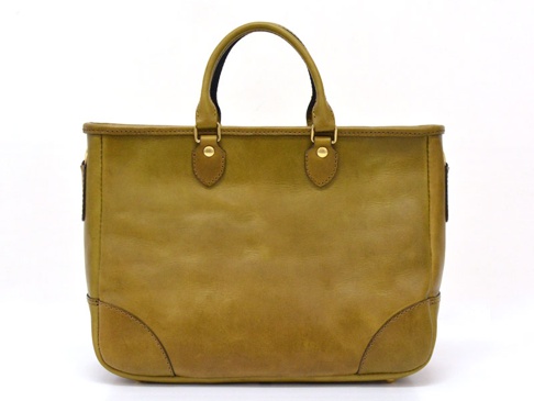 職人手作皮革兩用商務托特包，呈現溫潤的黃褐色調，材質為柔軟的皮革，包款設計簡潔，配有雙提把，底部有加固的皮革拼接，整體風格經典實用。