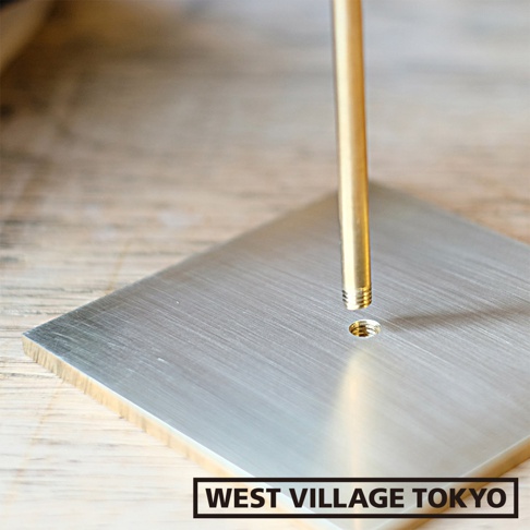 黃銅一輪花器/燈具展示架的底座為方形拉絲金屬，頂端為一根細長的黃銅管，管身有螺紋，正對著底座上的螺孔。