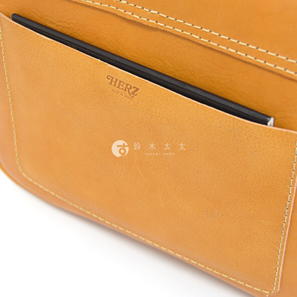 日本HERZ品牌皮革斜背包特寫，可見品牌壓印和內部收納空間。