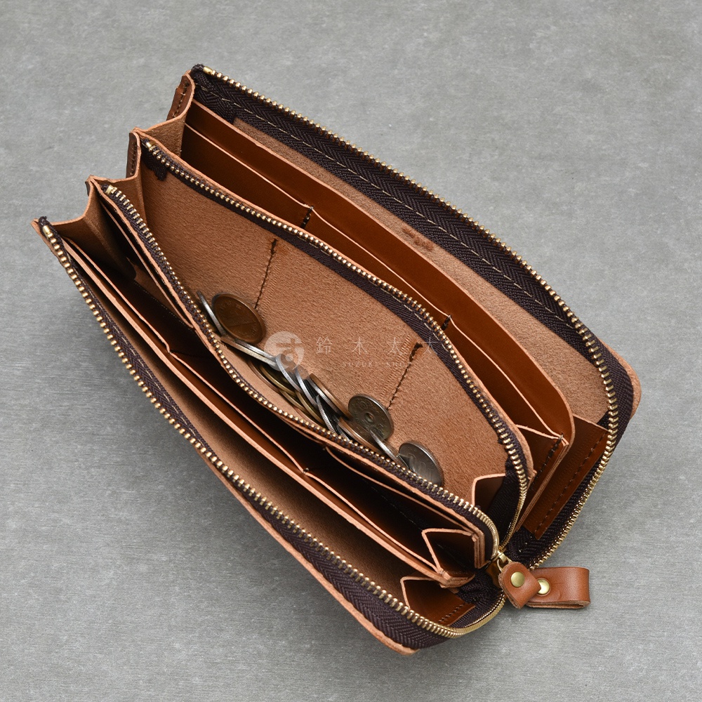 職人手作皮夾內部，展示多個隔層與零錢袋，並置有數枚硬幣。