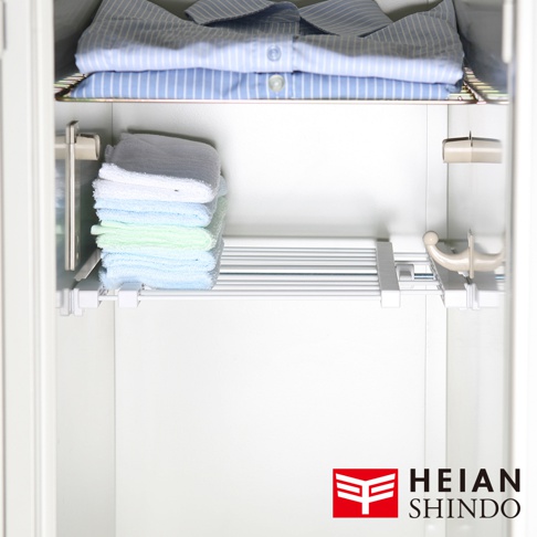 平安伸銅品牌標誌與全功能伸縮縫隙置物架，展示疊放的衣物與毛巾