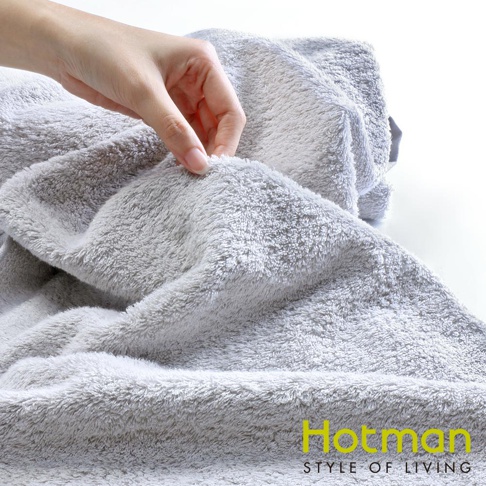 一條柔軟的灰色吸水乾髮巾，材質為絨毛，手部正在觸摸其蓬鬆的質地。