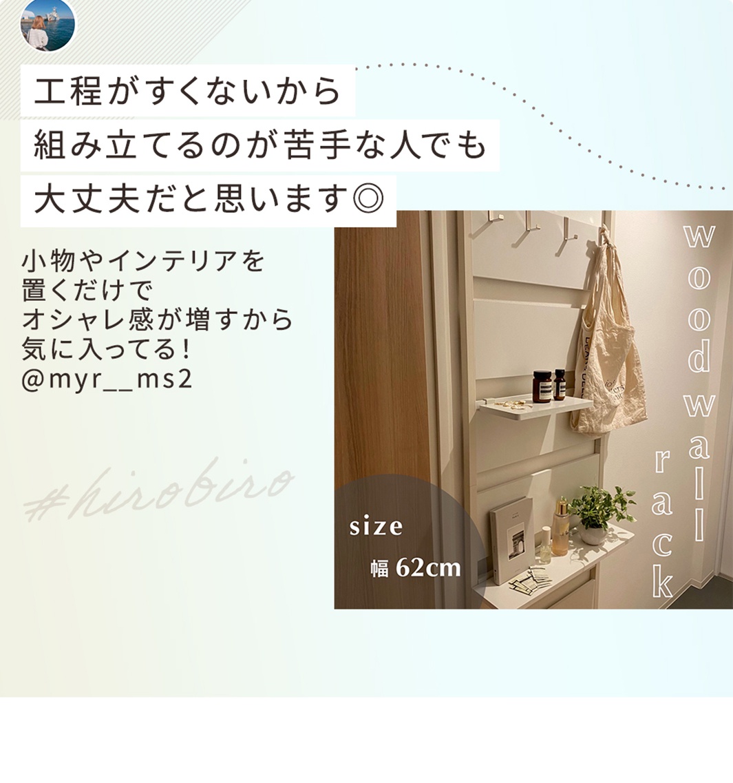 頂天立地木質收納架，白色，設有兩個置物層板和吊掛鉤，上面掛著一個米白色帆布袋，層板上擺放著書籍、瓶狀物和植物。