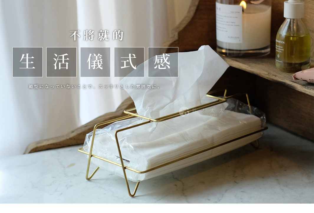 黃銅金屬質感的面紙盒，線條簡潔，內部裝有白色面紙，呈現現代簡約風格。
