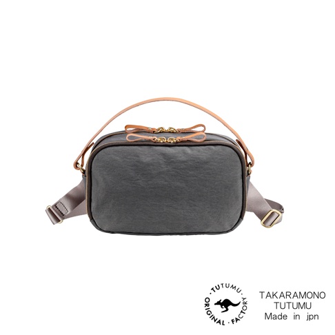 TUTUMURectangle防潑水兩用斜背包，灰色帆布材質，金色拉鍊，搭配皮革提把和織帶，下方印有TUTUMU的袋鼠圖案Logo及TAKaramono TUTUMU Made in jpn文字。
