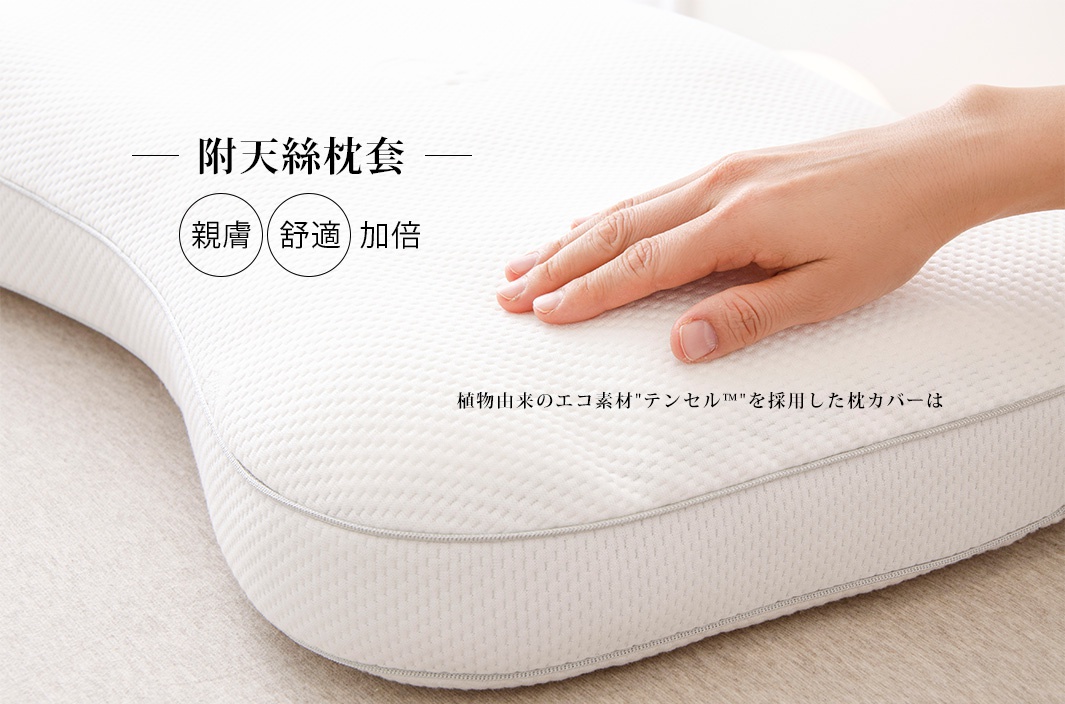 白色王樣の極柔枕，枕套為天絲 TENCEL 材質，表面有細緻的織紋。一只手輕柔地按壓枕頭表面。
