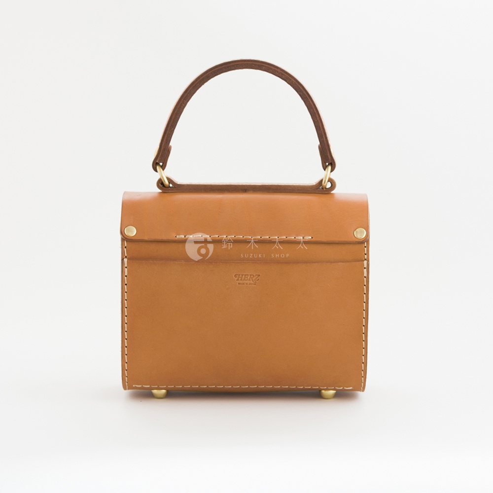 職人手作皮革復古杜勒斯手提包，採用棕褐色皮革製成，設計簡潔，配有頂部提把與金屬釦件，底部有四個金屬腳釘，整體呈現復古風格。