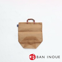 一個棕色麻質的提把收納袋，袋面有網狀透氣設計，提把為紅白色條紋織帶，袋旁有藍色小標籤。