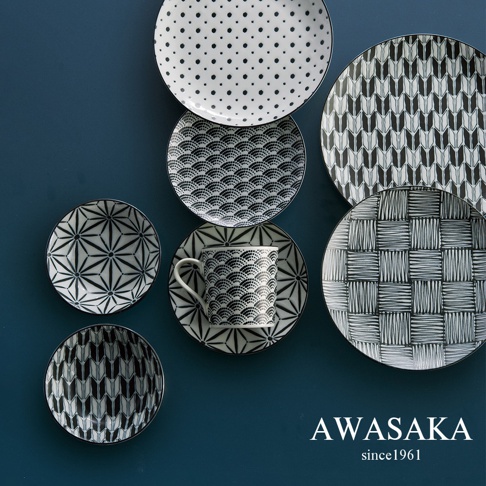 黑白兩色陶瓷餐具組，包含帶有圓點、波浪紋、箭羽紋、星形紋和編織紋圖案的盤子及馬克杯。