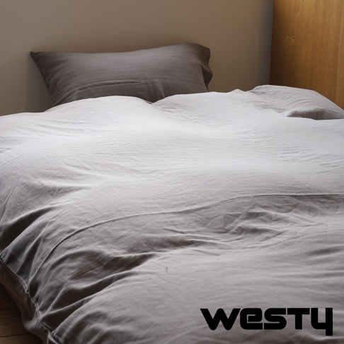 白色棉被搭灰色枕頭，被套上有WESTY品牌浮水印