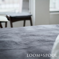 單人尺寸的 SERENE 美麗諾羊毛保暖墊，呈深灰色，質地厚實柔軟。