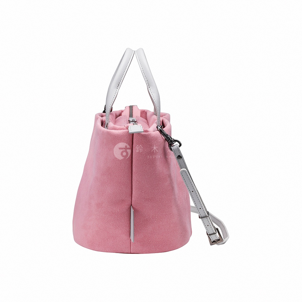 粉紅色絨面材質的小型手提包，有白色提把與可拆卸斜背帶，包側有品牌「SUZUKI SHOP」的標誌