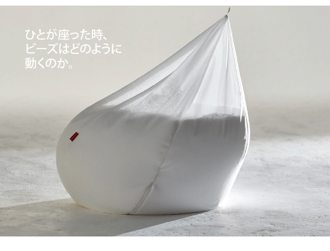 白色皮革懶骨頭沙發，內部填充白色顆粒，頂部開口處有細繩，沙發側面有一個紅色標籤。