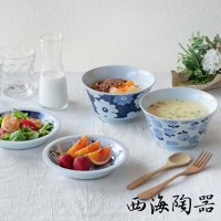 波佐見燒藍花紋四件式丼飯碗盤組，包含兩個大小不同的藍花紋陶瓷碗，一個裝有麥片水果，另一個裝有濃湯。另有兩個小盤，分別裝有沙拉和水果，以及一組木質湯匙叉子。