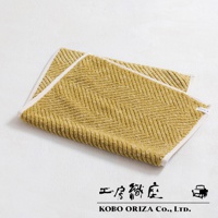 黃色棉麻混紡人字紋浴墊，帶有白色滾邊，質地柔軟。