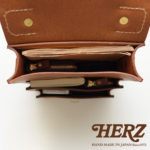 職人手作皮革單肩兩用小方包 A-10，棕色皮革，包內裝有筆記本和零錢包，結構清晰，展現精緻手工。