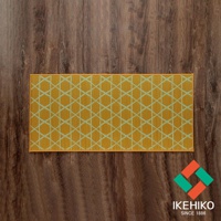 黃色榻榻米廚房地墊，織有淺綠色幾何菱形圖案，邊緣為橙黃色滾邊，置於木紋地板上。