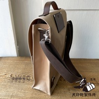 犬印純綿帆布三用直式側背包，米白色帆布主體搭配棕色皮革提把與肩帶，側面有金屬掛鉤與調節環，包蓋上有品牌壓印皮標。