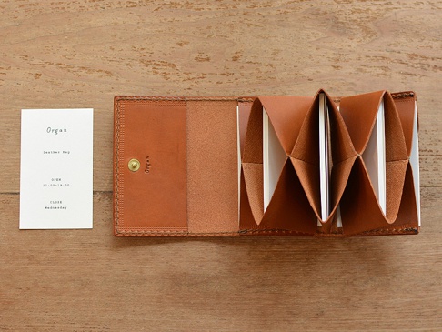 職人手作皮革Organ證件分類收納夾，寬版棕色，打開狀態，內部有數個卡槽，附有品牌吊牌。