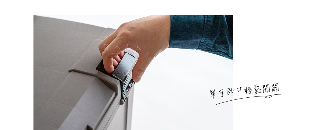 灰色塑膠收納箱的特寫，一隻手正操作著箱子的銀灰色卡扣。