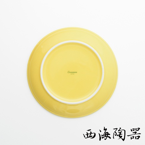 黃色陶瓷料理盤，底部有「Common JAPAN」字樣，盤緣有白色細邊。