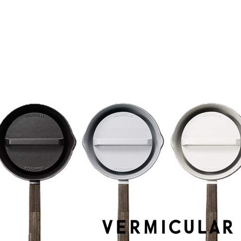 三款不同顏色的 Vermicular 琺瑯鑄鐵雪平鍋專用落蓋，由左至右分別為黑色、灰色與白色，蓋頂皆印有 Vermicular 字樣並設有直式握把，下方連接木紋質感把手，整體風格簡約現代。