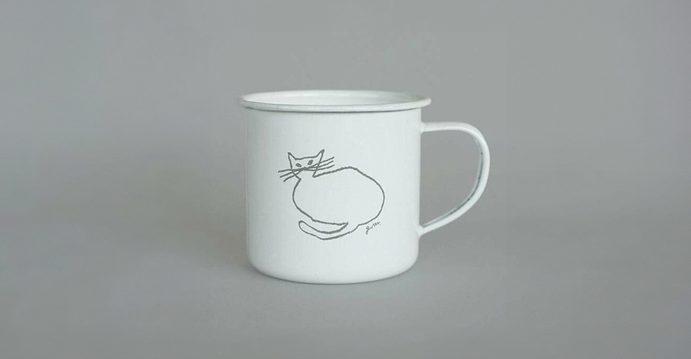 白色琺瑯馬克杯，印有手繪風格的灰色貓咪圖案，杯緣帶有輕微的磨損痕跡。