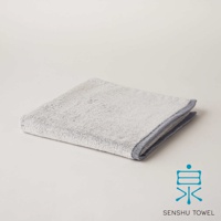 YUKINONE 雪之音柔織有機棉浴巾，淺灰色，觸感柔軟，邊緣有深藍色滾邊。
