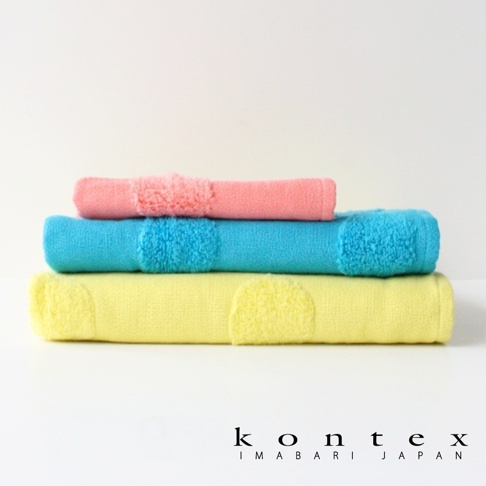 三條堆疊的今治無撚紗質柔膚浴巾，顏色分別為粉紅色、藍綠色和黃色，浴巾上帶有水玉點點的織紋。