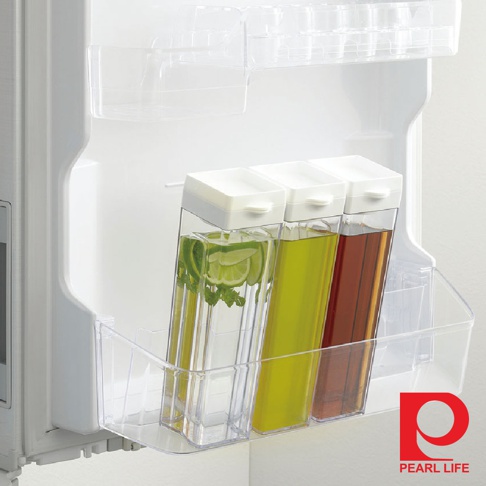 Pearl Life 品牌的冰箱冷水壺，內有檸檬片和薄荷葉，以及另外兩個裝有黃色液體和褐色液體的壺，放置在冰箱門側的透明收納籃中。