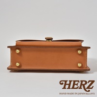 職人手作皮革三用單扣商務後背包 BC-4，採用天然皮革材質，呈現溫潤的棕褐色，側面有單一金屬扣環，搭配四顆金屬鉚釘，整體設計簡約大方，適合商務場合使用。