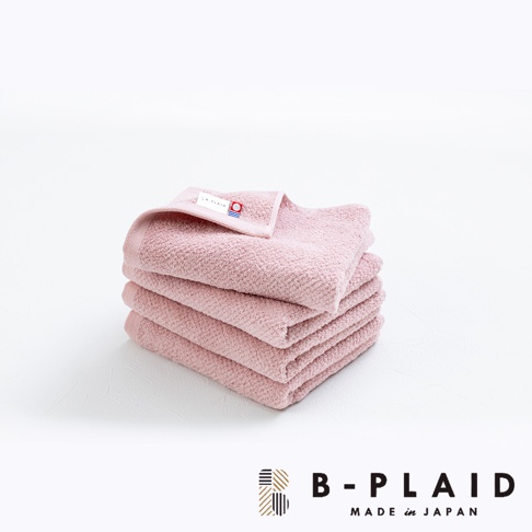 一疊粉紅色EVE今治毛巾，表面有鱗紋織紋，材質為棉，其中一條毛巾上縫有品牌標籤。