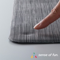 灰色編織紋理的廚房地墊，表面有紋理，一根手指輕壓在上面，顯示其柔軟度。