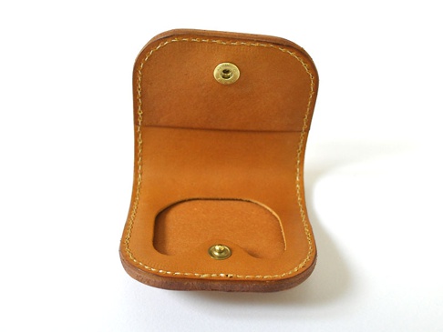 職人手作皮革馬蹄造型零錢包，採用天然棕色皮革，車縫線清晰，設有金屬按扣，造型簡約實用。