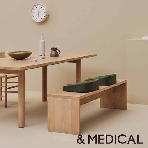 兩個綠色低反發美姿支撐坐墊放置在木質長凳上。