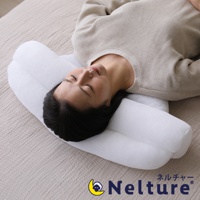 一名女子平躺在床墊上，頭部枕在一個白色、網狀材質的瑜珈感安睡枕上。枕頭設計有凹槽，能支撐頭部與頸部。